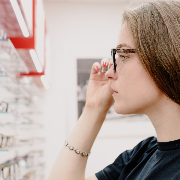 Image of woman at eye doctor trying on glasses.